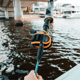 Baitcast Reel Cover fitted on a rod with angler walking along a city harbour bridge