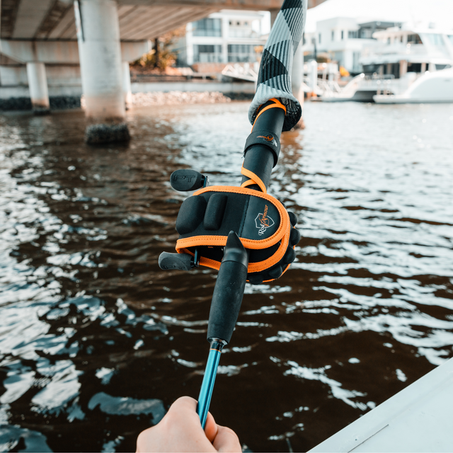 Baitcast Reel Cover fitted on a rod with angler walking along a city harbour bridge