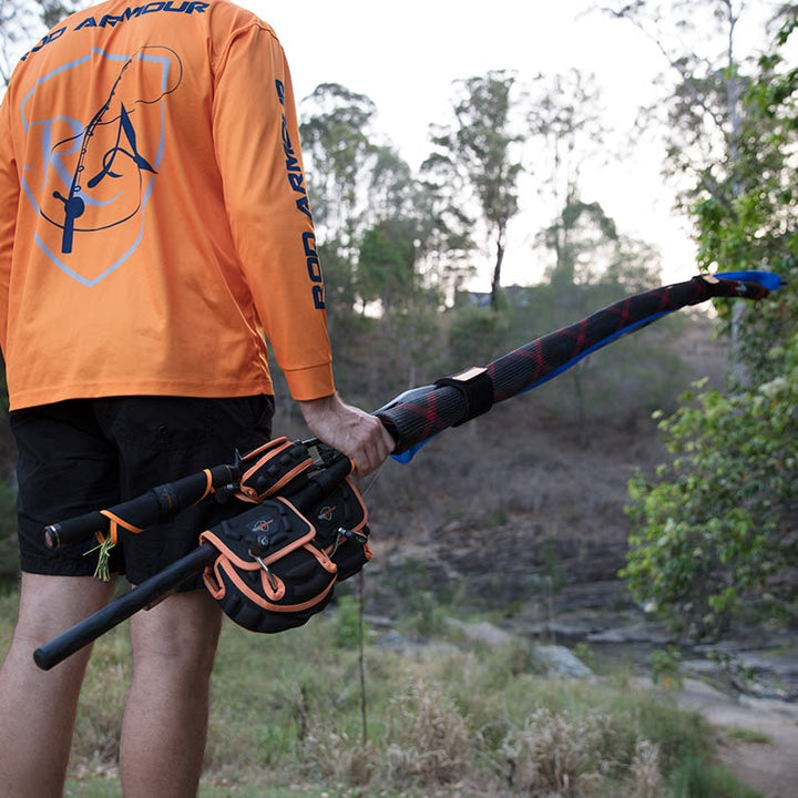 Person holding black and orange spinning reel case